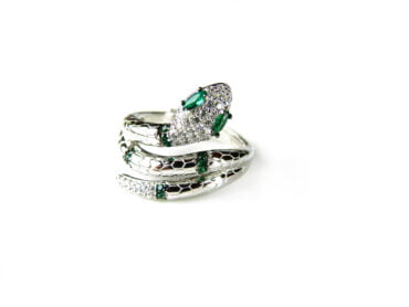 Ring in zilver model slang gezet met groene stenen en transparante cubic zirconia