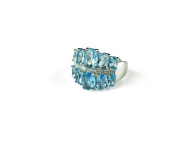 Brede zilveren ring gezet met licht blauwe stenen en cubic zirconia