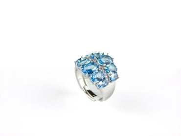 Brede zilveren ring gezet met licht blauwe stenen en cubic zirconia